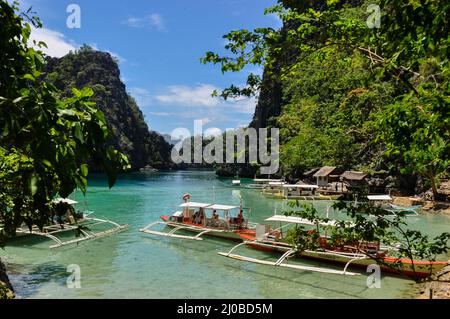 Traditionelle philippinische Holzboote in einer blauen Lagune im tropical island Stockfoto