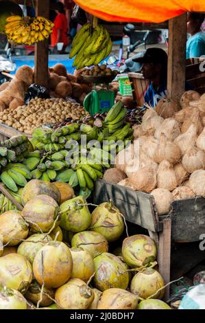 Anbieter verkaufen Kokosnüsse und grüne Bananen am lokalen Markt in Indonesien Stockfoto