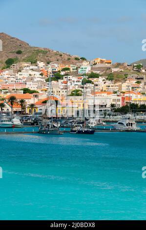 Boote vor einer kleinen Stadt an der blauen Ozeanküste mit Berghintergrund, Kap Verde Stockfoto