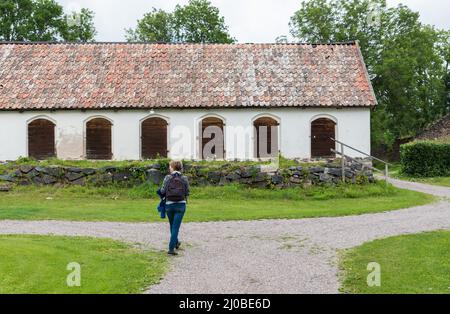 Forsmark, Osthammar - Schweden - 07 31 2019 Touristen zu Fuß zu einem alten Bauernhaus Stockfoto