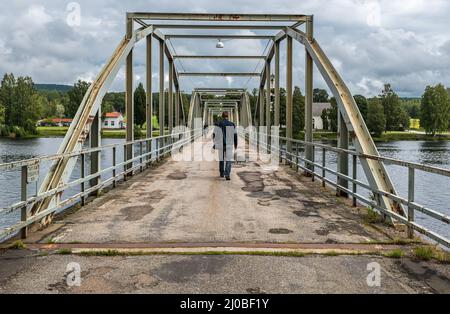 Segersta, Bollnas Gemeinde - Schweden - 08 03 2019: Mann, der über die Millenium Brücke läuft Stockfoto