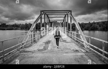 Segersta, Bollnas Gemeinde - Schweden - 08 03 2019: Mann, der über die Millenium Brücke läuft Stockfoto