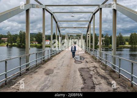Segersta, Bollnas Gemeinde / Schweden - 08 03 2019: Frau beim Spaziergang über die Milleniumbrücke Stockfoto