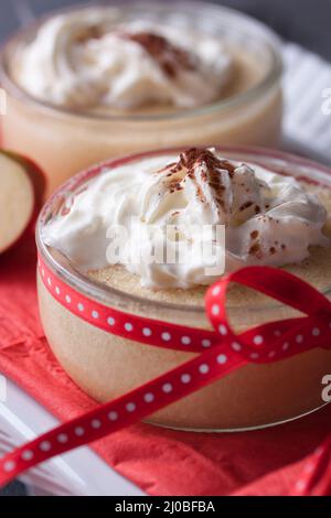 Apfelmus-Dessert mit Creme und frischen Äpfeln in einem Glas auf einem weißen Tee-Tablett Stockfoto