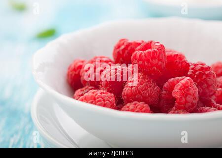 Frische Himbeeren in einer weißen Keramikschale. Stockfoto