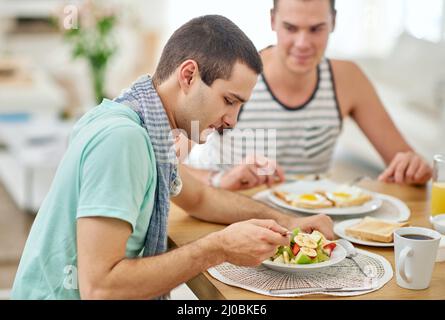 Genießen Sie ein gutes Essen und sich gegenseitig Gesellschaft. Aufnahme eines schwulen Paares, das zusammen zu Mittag gegessen hat. Stockfoto