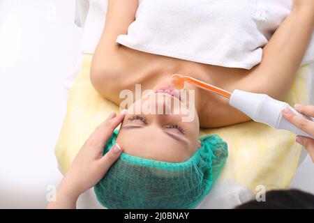 Erhalten elektrische Darsonval Gesichtsmassage Verfahren. Stockfoto