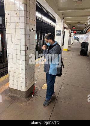 Blinder Mann auf dem U-Bahnsteig, der in Brooklyn, New York, auf einen Zug wartet. Stockfoto