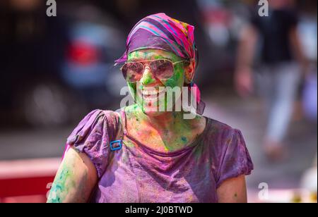 Neu-Delhi, Indien. 18. März 2022. Eine Frau, die mit farbigem Pulver beschmiert wird, feiert das Festival der Farben Holi in Neu-Delhi, Indien, 18. März 2022. Quelle: Javed Dar/Xinhua/Alamy Live News Stockfoto