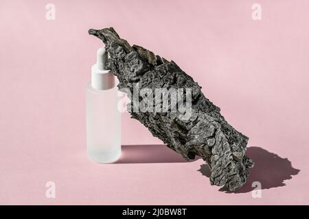 Serum-Kosmetikflasche Mockup mit Rindenbaum auf rosa Hintergrund, Schatten von der Sonne, natürliches Licht von Fenstern. Transparentes flüssiges Produkt aus Glas Stockfoto