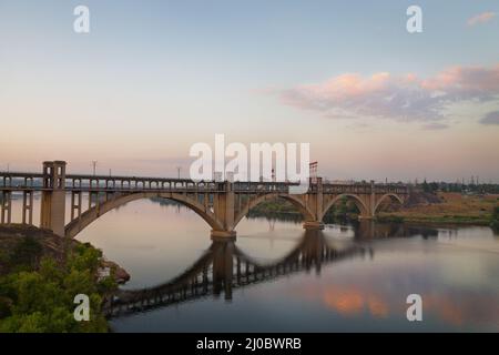 Sonnenuntergang auf dem Dnepr. Brücke in Zaporozhye Stockfoto