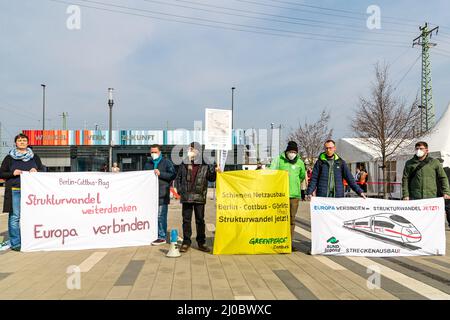 Cottbus, Deutschland. 18. März 2022. Vor dem neuen Infopunkt am Bahnhof Cottbus stehen Demonstranten von Umweltorganisationen, die für eine erweiterte Eisenbahnlinie demonstrieren und ausdrücklich die Strecke Berlin - Cottbus - Görlitz - Prag erwähnen. Am Cottbus Hauptbahnhof wurde heute eine Informationsstelle des Cottbuser Eisenbahnwerks eröffnet. Die ersten ICE-Züge werden ab 2024 im derzeit im Bau befindlichen Bahnwerk gewartet. Quelle: Frank Hammerschmidt/dpa/Alamy Live News Stockfoto