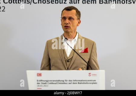 Cottbus, Deutschland. 18. März 2022. Holger Kelch, Oberbürgermeister der Stadt Cottbus, grüßt bei der Eröffnung der Infopunkt des Cottbuser Eisenbahnwerks auf dem Vorplatz des Cottbuser Hauptbahnhofs. Am Cottbus Hauptbahnhof wurde heute eine Informationsstelle des Cottbuser Eisenbahnwerks eröffnet. Die ersten ICE-Züge werden ab 2024 im derzeit im Bau befindlichen Bahnwerk gewartet. Quelle: Frank Hammerschmidt/dpa/Alamy Live News Stockfoto