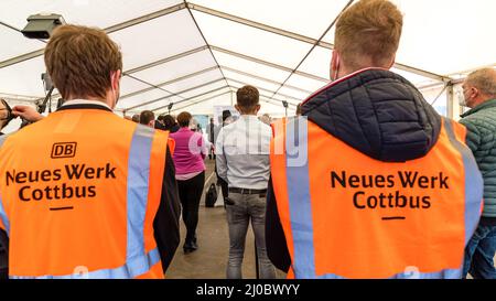 Cottbus, Deutschland. 18. März 2022. Die Teilnehmer der Eröffnungsveranstaltung des neuen Infopunkts am Bahnhof Cottbus hören einem Redner zu. Am Cottbus Hauptbahnhof wurde heute eine Infopunkt für das Cottbuser Bahnwerk eröffnet. Die ersten ICE-Züge werden ab 2024 im derzeit im Bau befindlichen Bahnwerk gewartet. Quelle: Frank Hammerschmidt/dpa/Alamy Live News Stockfoto