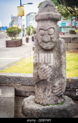 Steinidol (Dolharubang, die Großvatersteine) vor Jeju Mokgwana, dem ältesten erhaltenen Gebäude in Jeju für ehemalige Cen Stockfoto