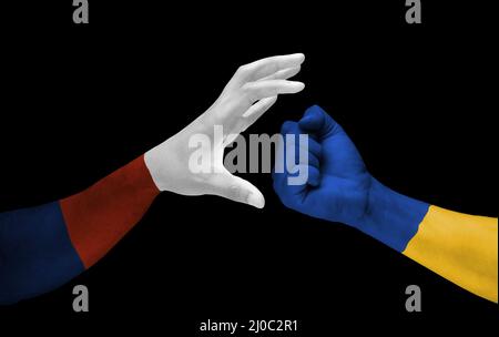 Hand mit Russland Flaggenfarben Angriffshand mit Flagge der Ukraine auf dunklem Hintergrund. Ukraine gegen Russland im Krisenkonzept des Weltkriegs Stockfoto