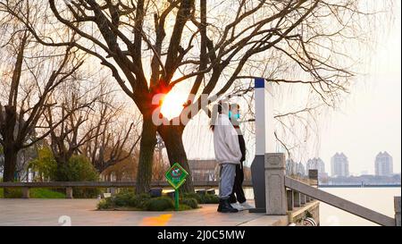 Suzhou, China. 23.. Februar 2022. Ein Paar mit Gesichtsmasken gesehen Blick auf eine Karte in einem Park mit Sonnenuntergang im Hintergrund. Suzhou ist eine Stadt, die 100 km von Shanghai entfernt liegt. Die Stadt befindet sich seit Ende Februar in Quarantäne, nachdem neue Fälle von Covid 19 entdeckt wurden. (Foto von Thibaud Mougin/SOPA Images/Sipa USA) Quelle: SIPA USA/Alamy Live News Stockfoto