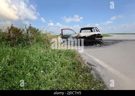 Ausgebrannte Autos am Straßenrand Stockfoto