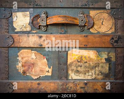 Vorderansicht eines alten verwitterten Reisekoffers mit alten leeren, abgenutzten Etiketten Stockfoto