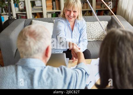 Finanzberater und Senioren geben sich nach einer Konsultation über Altersvorsorge und Altersvorsorge die Hände Stockfoto