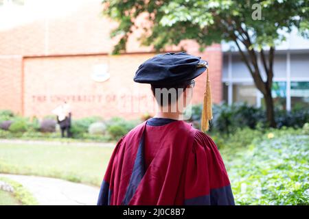 Zwei glückliche stolze Doktoranden graduierten männliche Studenten in akademischem Kleid. Rückansicht Stockfoto