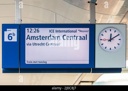 ARNHEM, NIEDERLANDE – 14. JANUAR 2014: Bahnsteigeanzeige mit Uhr auf einem niederländischen Bahnhof in Arnhem, die die Abfahrtszeit anzeigt Stockfoto