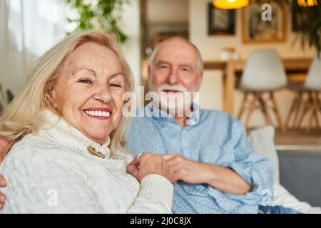 Glückliches Rentnerehepaar, das entspannt zu Hause oder im Ruhestand sitzt Stockfoto