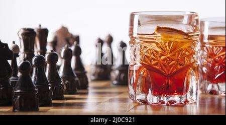 Schachfiguren und Whiskyglas Stockfoto