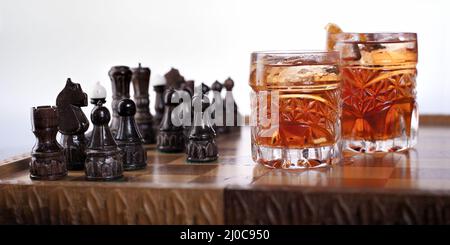 Schachfiguren und Whiskyglas Stockfoto