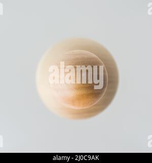 Surreale Designkonzept - echte Holzkugel Schwimmer auf grauem Hintergrund wie der Planet über das Universum Stockfoto