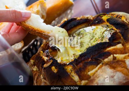 Camembert Fondue in Brotschale Stockfoto