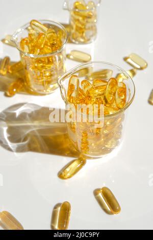 Fischöl-Kapseln in transparenten Laborflaschen.gesunde Ernährung und Nahrungsergänzungsmittel.Omega-Fettsäuren.natürliche Nahrungsergänzungsmittel und Vitamin Stockfoto