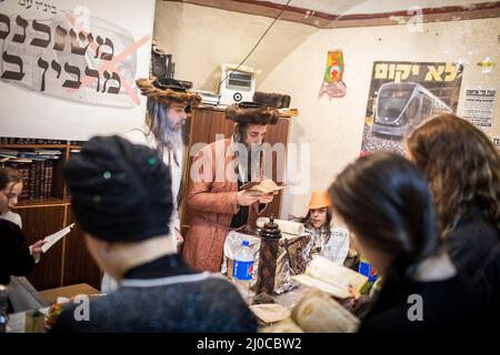 Jerusalem, Israel. 18. März 2022. Ultra-orthodoxe Juden lasen Gebete während der Feierlichkeiten zum jüdischen Feiertag von Purim in Jerusalems streng religiösem Viertel Mea She'arim. Purim, auch das Fest der Lose genannt, ist ein Karneval-ähnlicher jüdischer Feiertag, der mit Paraden und Costunes gefeiert wird, um an die Rettung des jüdischen Volkes vor einem Plan zu erinnern, alle Juden im alten persischen Reich zu massakrieren, wie es im Buch Esther beschrieben wird. Quelle: Ilia Yefimovich/dpa/Alamy Live News Stockfoto