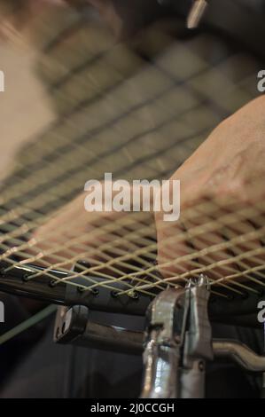 Schlägerbesaitung. Detail des Tennisschlägers in der Stringing-Maschine Stockfoto