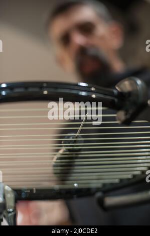 Schlägerbesaitung. Detail des Tennisschlägers in der Stringing-Maschine Stockfoto