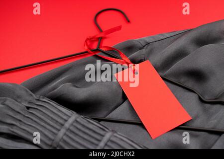 Layout, Beschriftung für Text in roter Farbe auf einer Seidenbluse, auf rotem Hintergrund Stockfoto