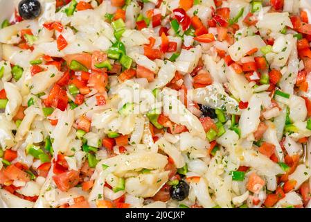 Hintergrund Kabeljausalat mit Tomatenpfeffer Zwiebel und Oliven Stockfoto