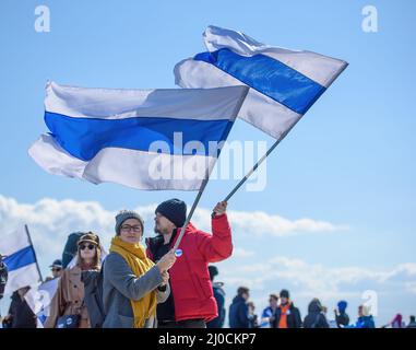 LIMASSOL, ZYPERN - 13. MÄRZ 2022: Zwei Demonstranten auf einer Kundgebung gegen die russische Invasion in der Ukraine halten weiß-blau-weiße Flaggen, ein Symbol für Anti-Kriegs-Pro Stockfoto