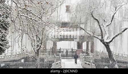 Peking, China. 18. März 2022. Die Menschen genießen den Blick auf den Schnee in einem Park in Peking, der Hauptstadt Chinas, 18. März 2022. Kredit: Li Xin/Xinhua/Alamy Live Nachrichten Stockfoto