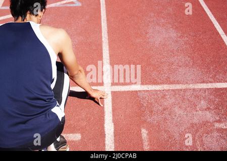 Hes liegt direkt auf der Strecke. Ein junger Athlet, der alleine trainiert. Stockfoto