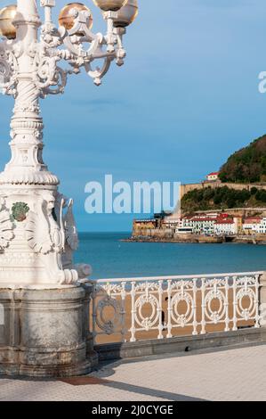 Wunderbar verzierte Lampenpfosten an der Promenade Playa de la Concha, San Sebastian, Spanien mit Blick auf Bahia de la Conch und die Altstadt Stockfoto