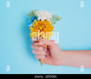 Zu viel von einer guten Sache ist wunderbar. Zugeschnittenes Bild einer nicht erkennbaren Frau, die einen mit Blumen gefüllten Kegel in der Hand hält. Stockfoto
