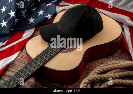 Freedom und american Country und Blues Musik Festival Konzept mit USA Flagge und Akustikgitarre mit einer schwarzen Kappe auf der Oberseite und Cowboy Lasso auf einem d platziert Stockfoto