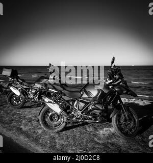 Zwei Offroad-Motorräder stehen nebeneinander am Meer Stockfoto