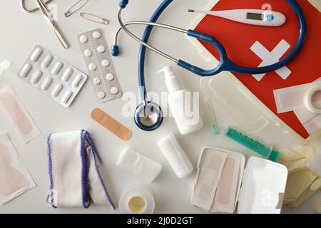 Sortiment an medizinischen Hilfsgeräten für erste Hilfe auf weißem Tisch. Horizontale Zusammensetzung. Draufsicht. Stockfoto