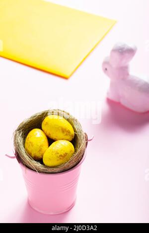 Ostereier und weißes Kaninchen auf rosa Hintergrund. Osterkonzept Stockfoto