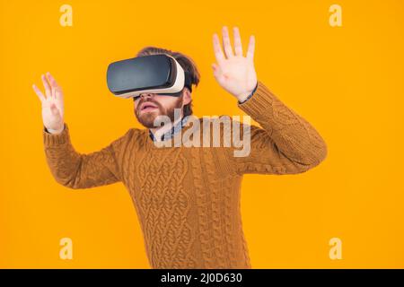 Der junge kaukasische Mann benutzte vr-Stachelschwanzeln, während er seine Hände in der Luft hochhob. Hochwertige Fotos Stockfoto