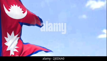 Detail der Nationalflagge Nepals, die an einem klaren Tag im Wind winkt. Nepal ist ein Binnenstaat in Südasien. Selektiver Fokus. Stockfoto