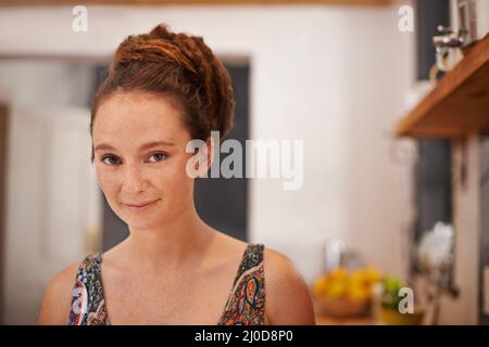 Shes hat einen alternativen Stil. Porträt einer jungen Frau mit Dreadlocks, die in ihrem Haus stehen. Stockfoto