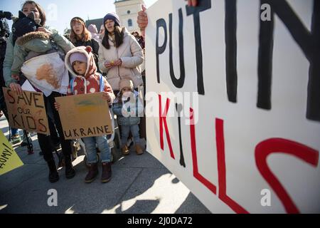 Warschau, Polen. 18. März 2022. Ukrainische Frauen und Kinder halten während des Protestes Plakate mit ihrer Meinung. Der "Marsch der ukrainischen Mütter" fand in Warschau statt, der auch ein Protest gegen den Krieg und die Tötung ukrainischer Kinder war. Die Parolen des marsches waren: "Welt, helft unseren Kindern", "Stoppt den Krieg", "rettet Kinder der Ukraine" und "schließt den Himmel". An dem Protest nahmen vor allem ukrainische Mütter und ihre Kinder Teil, die vor dem Krieg in Polen Zuflucht fanden. Kredit: SOPA Images Limited/Alamy Live Nachrichten Stockfoto